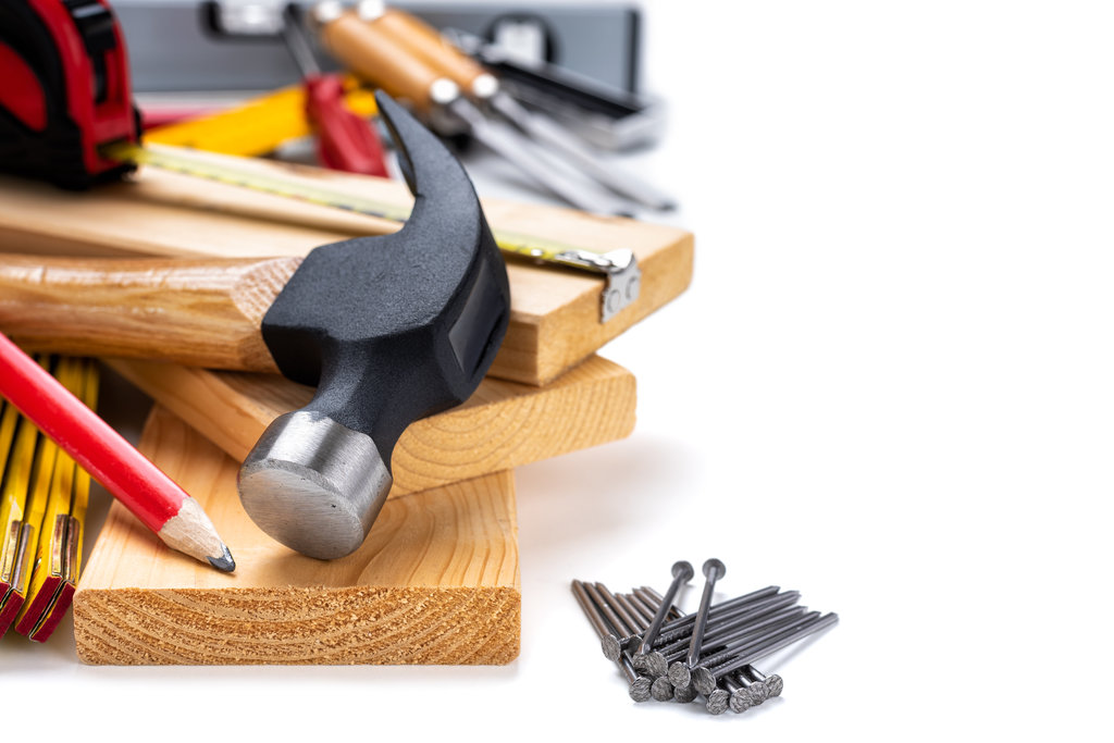 Blick auf einen Hammer, Nägel, Bleistift, Holzbretter und andere Materialien auf weißem Hintergrund