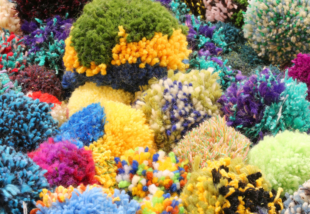 close-up van een cluster pom-poms in alle kleuren